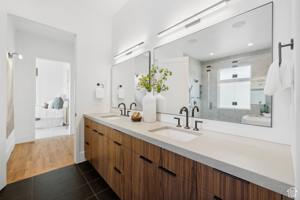 Bathroom with walk in shower, tile patterned floors, and double sink vanity