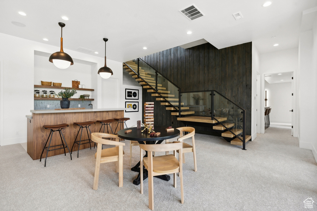 Carpeted dining space with bar