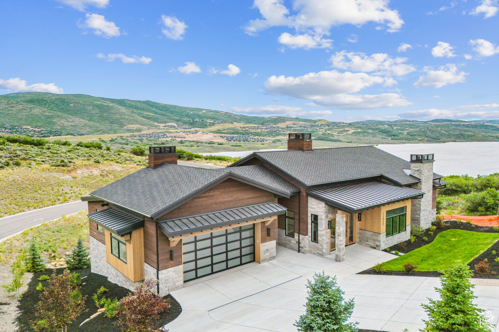 View of front of property with a garage and a mountain view