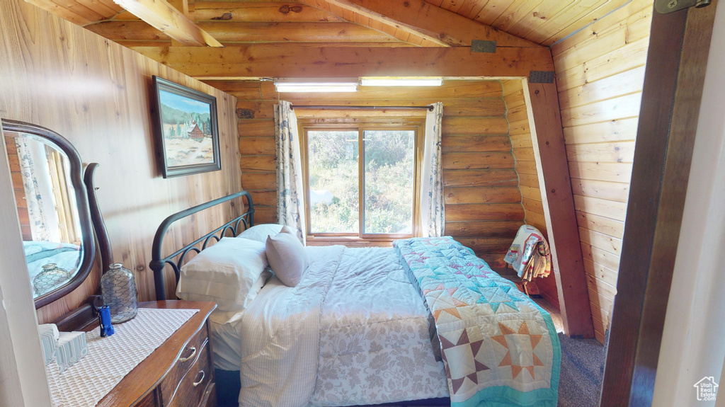 Bedroom featuring lofted ceiling, wood ceiling, and log walls