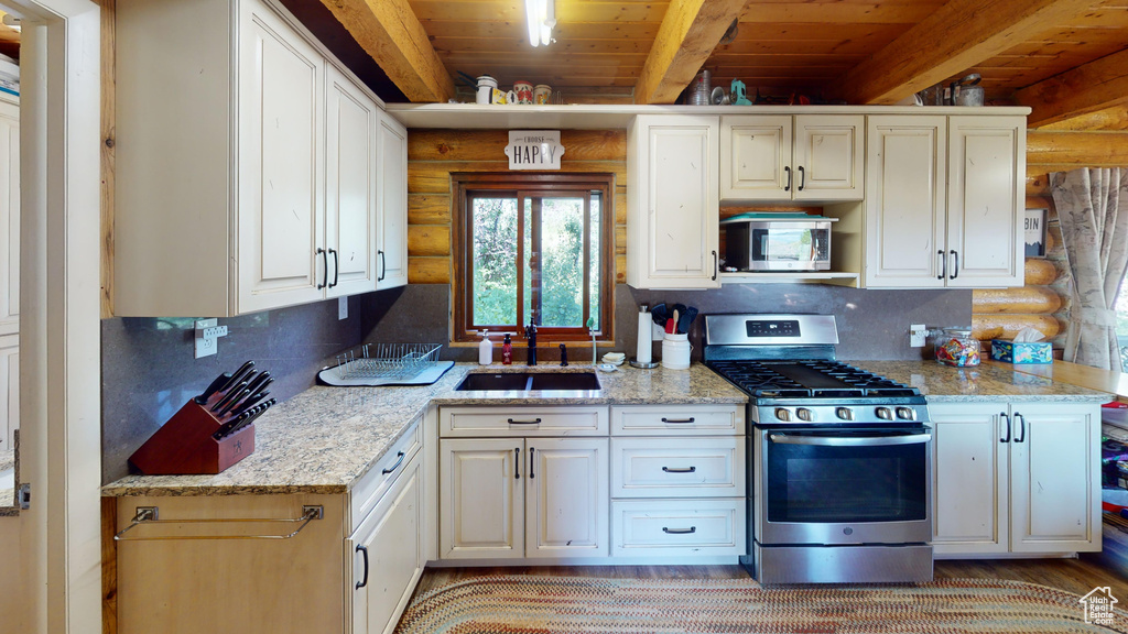 Kitchen featuring wooden ceiling, tasteful backsplash, stainless steel appliances, and beam ceiling