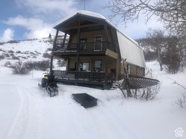 Snow covered property with a balcony