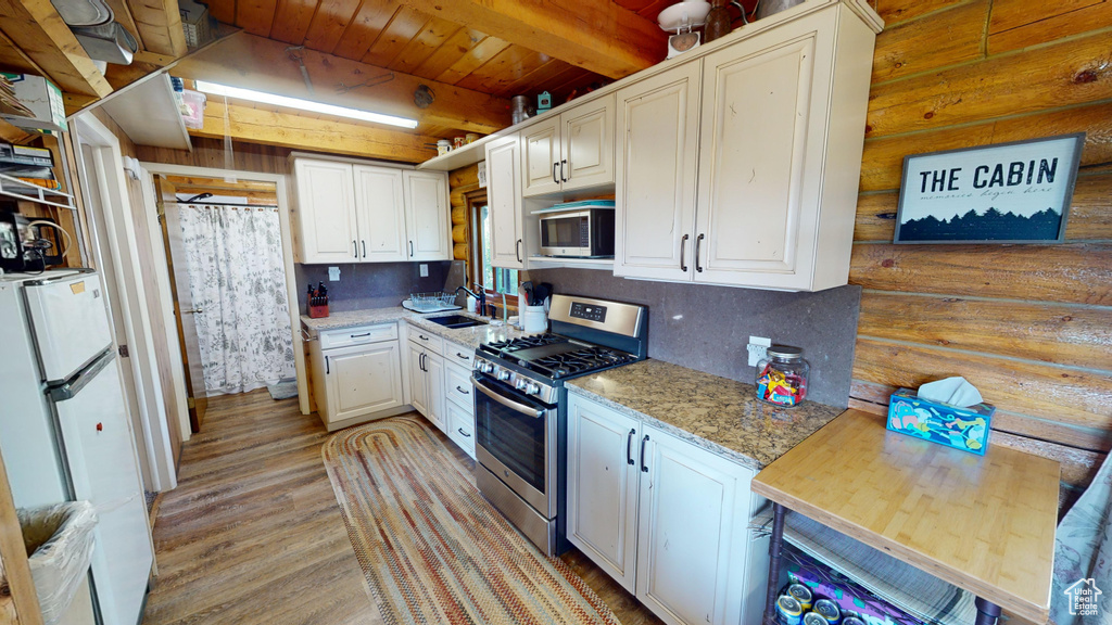 Kitchen with beamed ceiling, stainless steel appliances, sink, wooden ceiling, and wood-type flooring