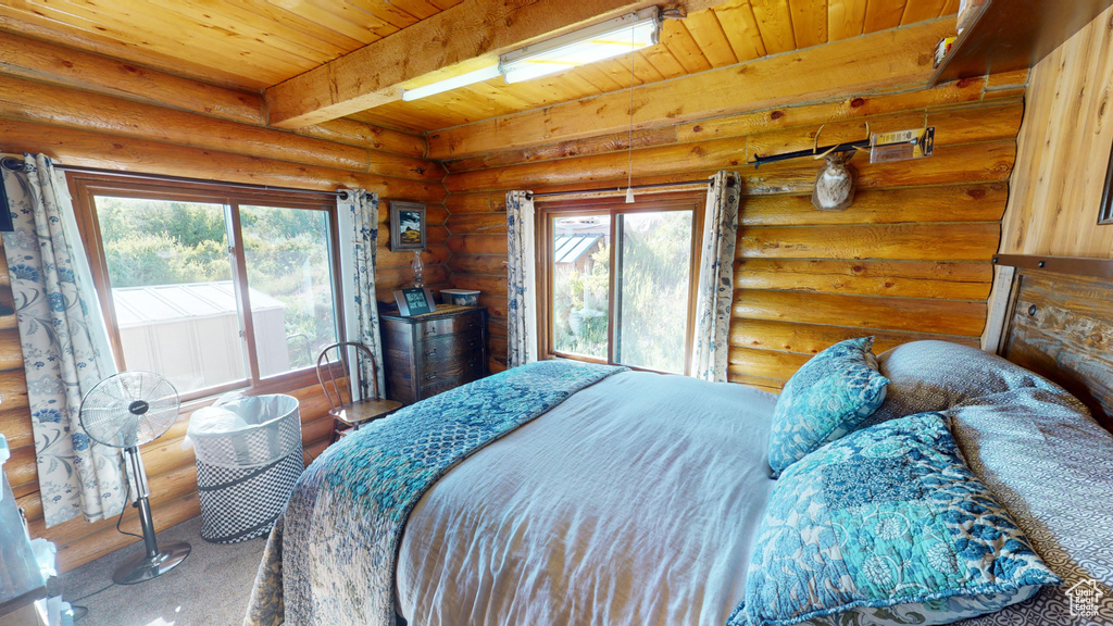 Bedroom with beam ceiling, access to outside, wood ceiling, and log walls