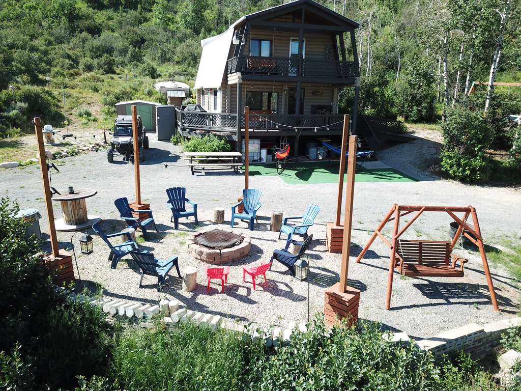 Exterior space featuring a balcony and an outdoor fire pit