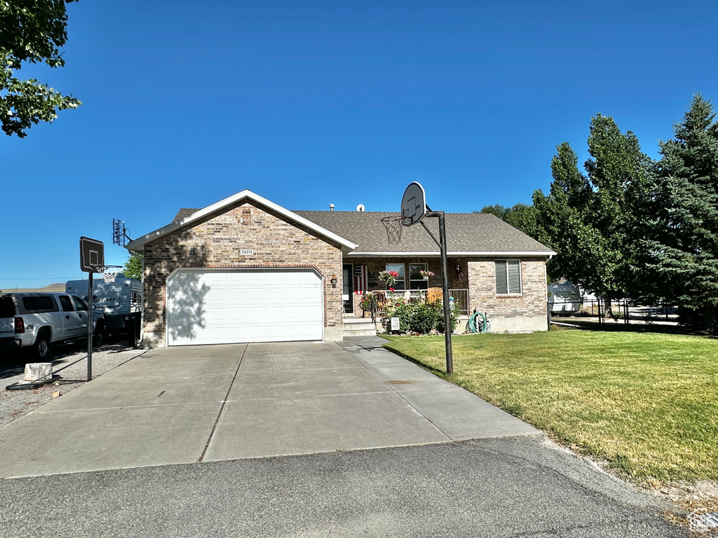 Ranch-style home with a garage and a front lawn