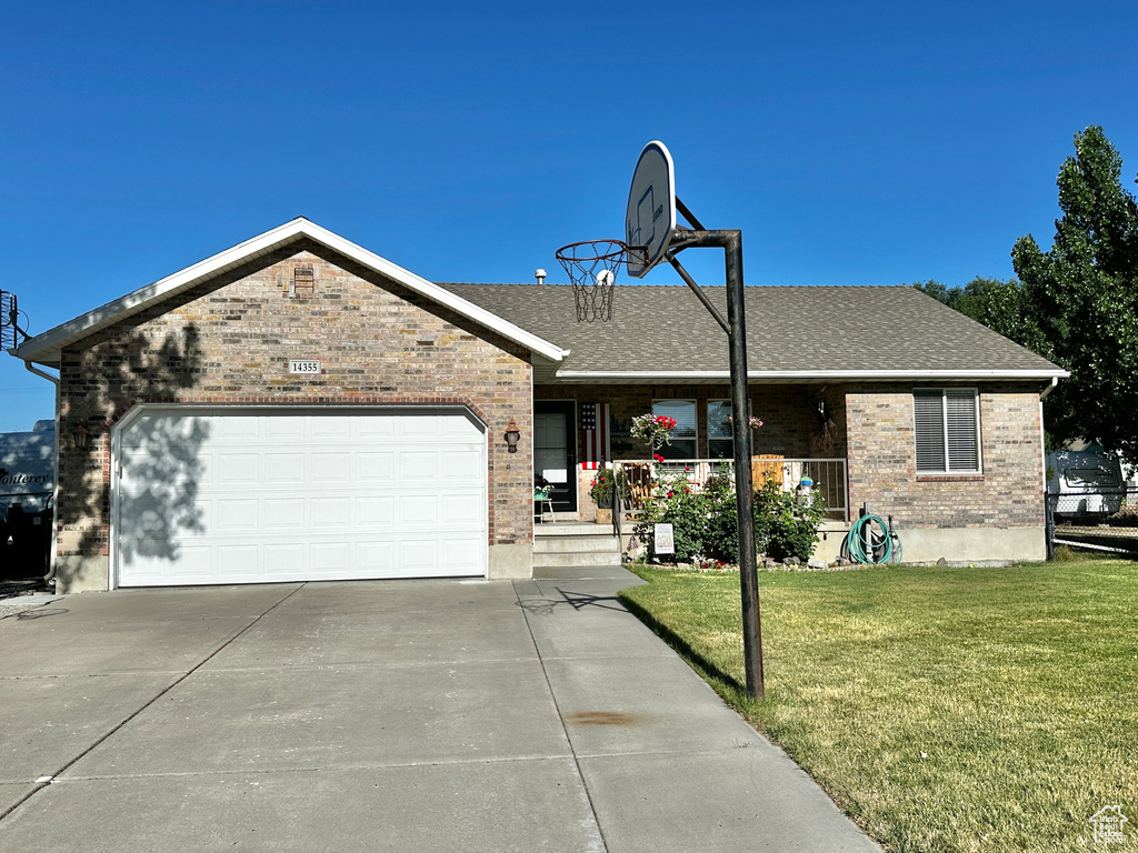 Single story home featuring a garage and a front yard