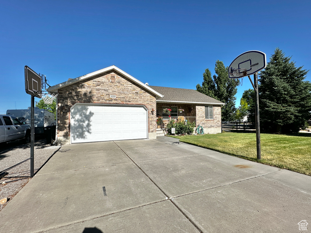 View of front of house featuring a garage and a front lawn