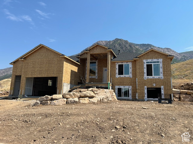 Unfinished property with a garage and a mountain view