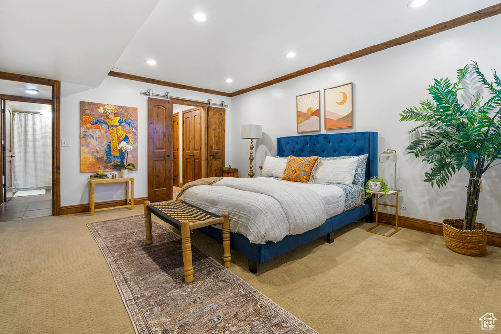 Carpeted bedroom with crown molding and a barn door