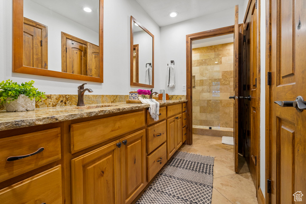 Bathroom featuring tiled shower, tile patterned floors, and vanity