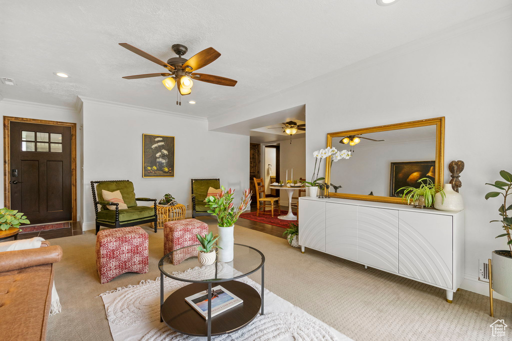 Living room featuring light carpet, crown molding, and ceiling fan