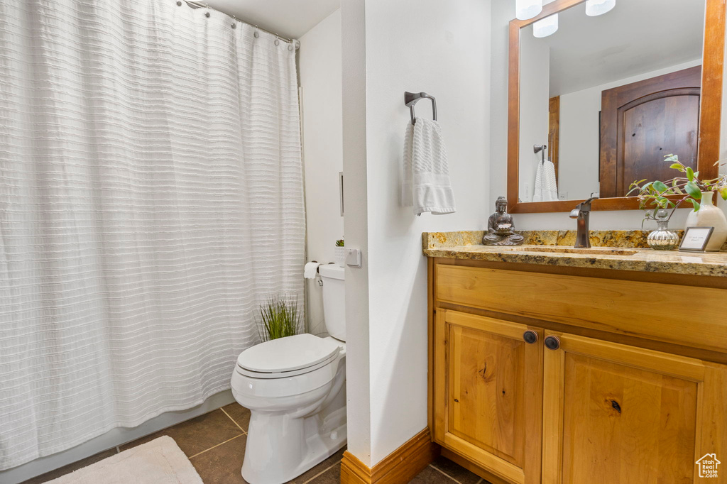 Bathroom with tile patterned floors, toilet, and vanity