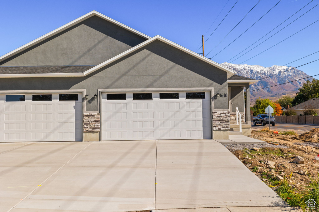 View of side of property featuring a mountain view and a garage