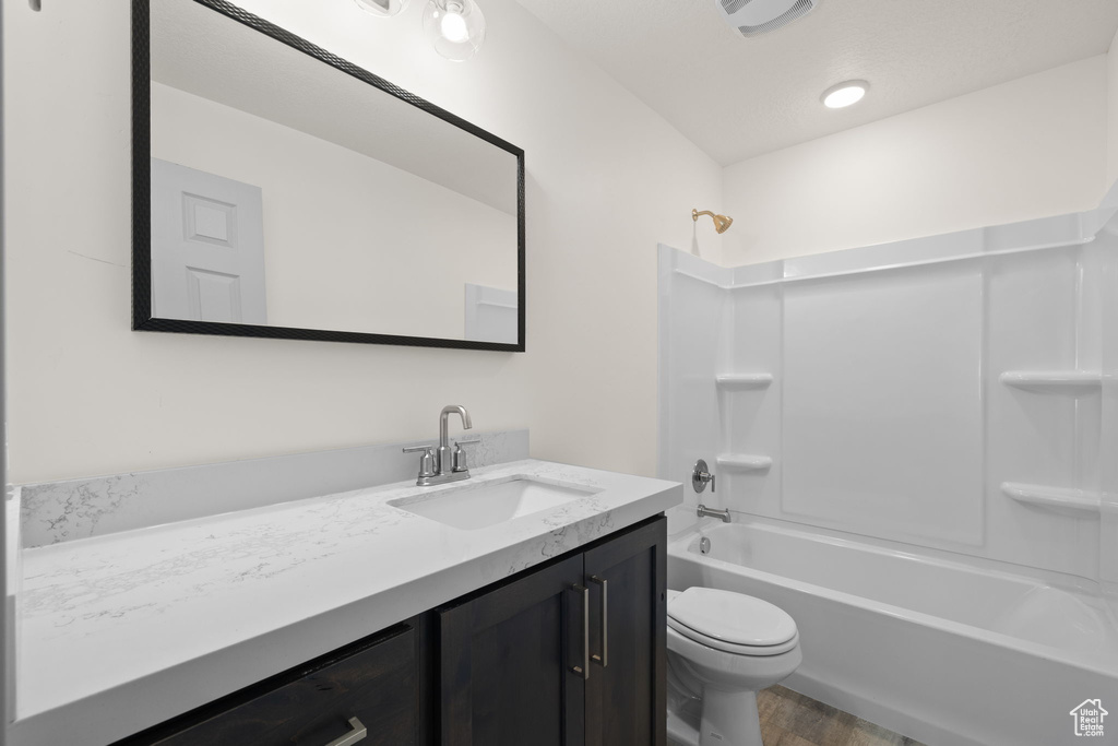 Full bathroom featuring vanity, toilet, shower / bath combination, and hardwood / wood-style flooring