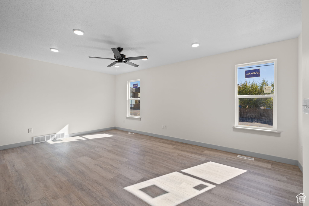 Unfurnished room with ceiling fan and light wood-type flooring