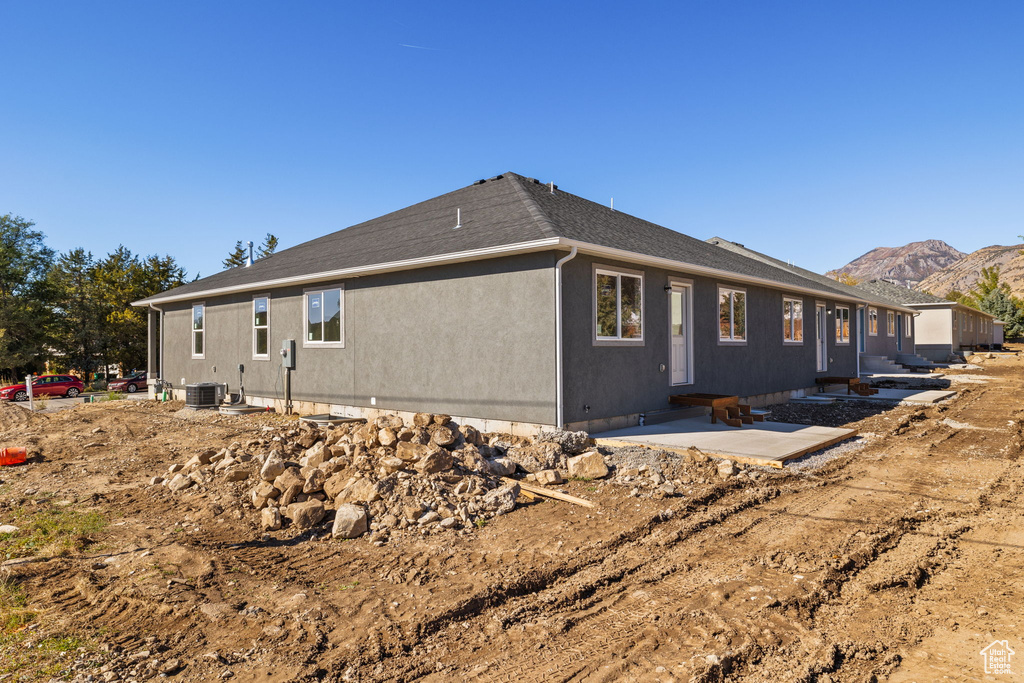 Rear view of property with central air condition unit, a patio area, and a mountain view