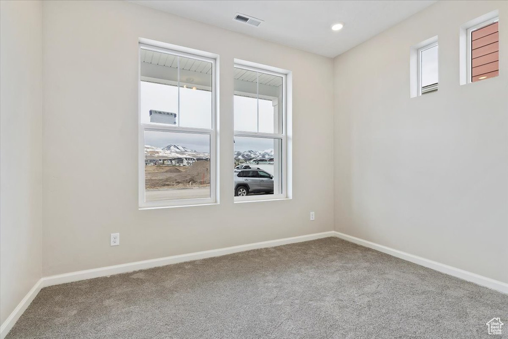 Unfurnished room with carpet flooring and a healthy amount of sunlight