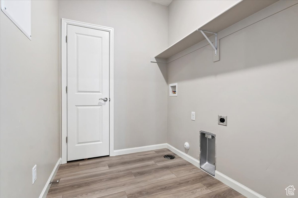 Washroom with hookup for a washing machine, gas dryer hookup, light hardwood / wood-style floors, and hookup for an electric dryer