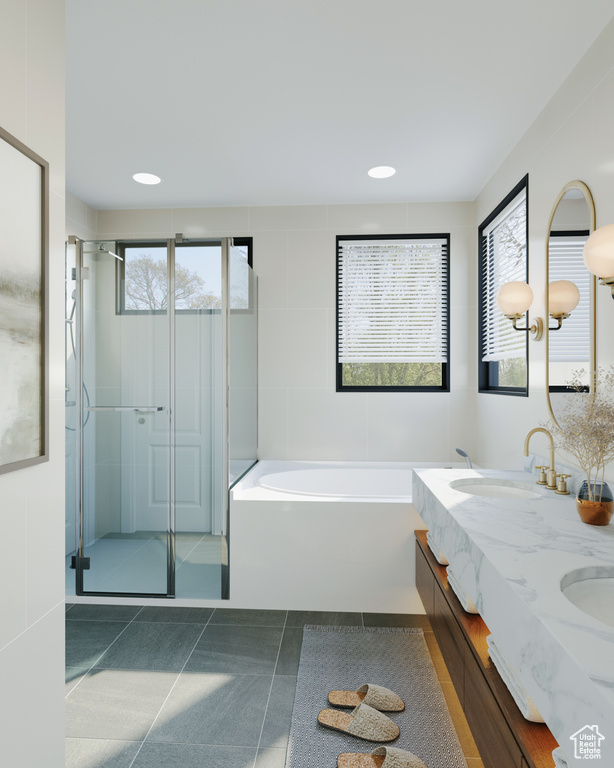 Bathroom with tile patterned floors, separate shower and tub, and double sink vanity