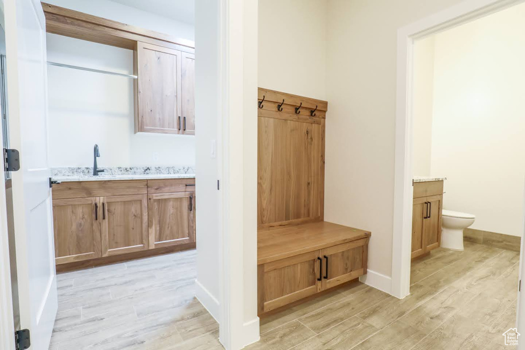 Mudroom featuring light wood-type flooring and sink