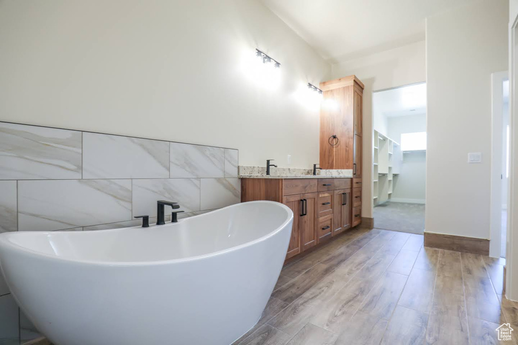 Bathroom with vanity, wood-type flooring, and a bathtub