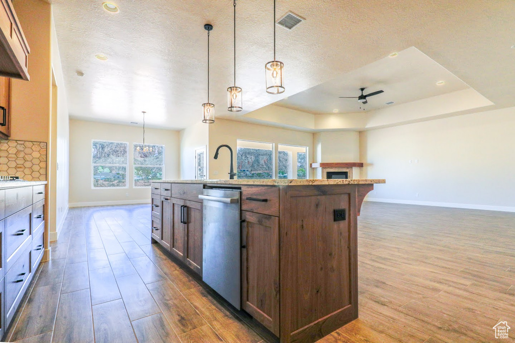 Kitchen featuring decorative light fixtures, dishwasher, ceiling fan, and plenty of natural light