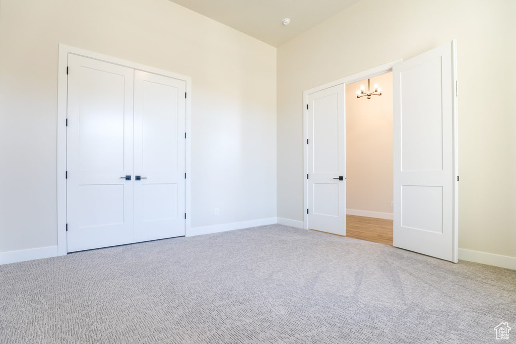 Unfurnished bedroom featuring a closet and light colored carpet