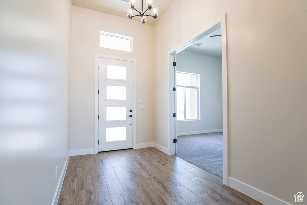 Foyer entrance with an inviting chandelier, hardwood / wood-style flooring, and a wealth of natural light