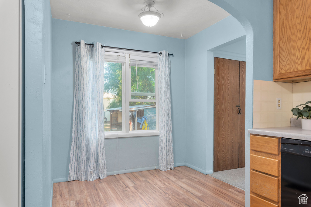 Kitchen featuring dishwasher, light hardwood / wood-style flooring, and tasteful backsplash