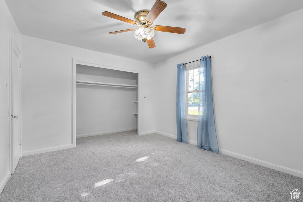 Unfurnished bedroom featuring a closet, carpet floors, and ceiling fan