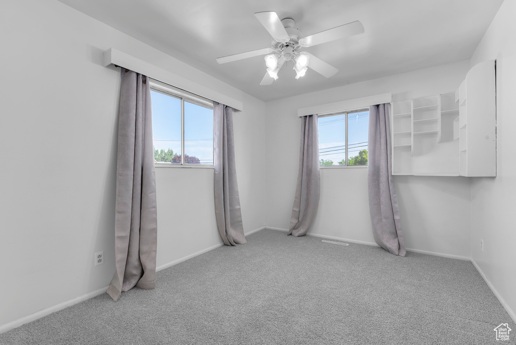 Spare room featuring carpet flooring and ceiling fan