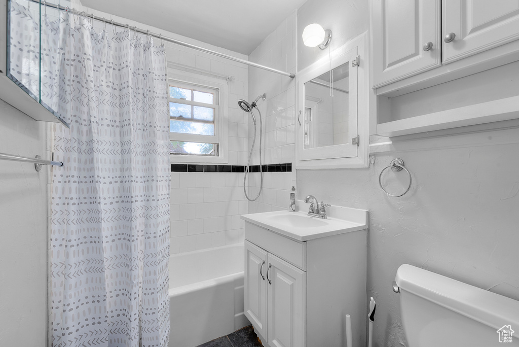 Full bathroom featuring vanity, shower / tub combo, and toilet