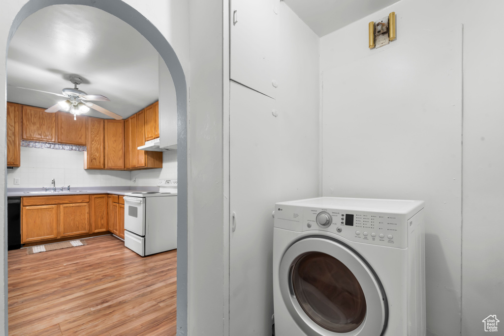 Laundry room with washer / clothes dryer, ceiling fan, sink, and light hardwood / wood-style flooring