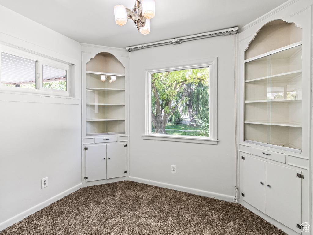 Interior space featuring a notable chandelier, carpet flooring, and plenty of natural light