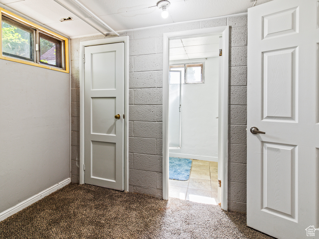 Hallway with a healthy amount of sunlight and dark carpet