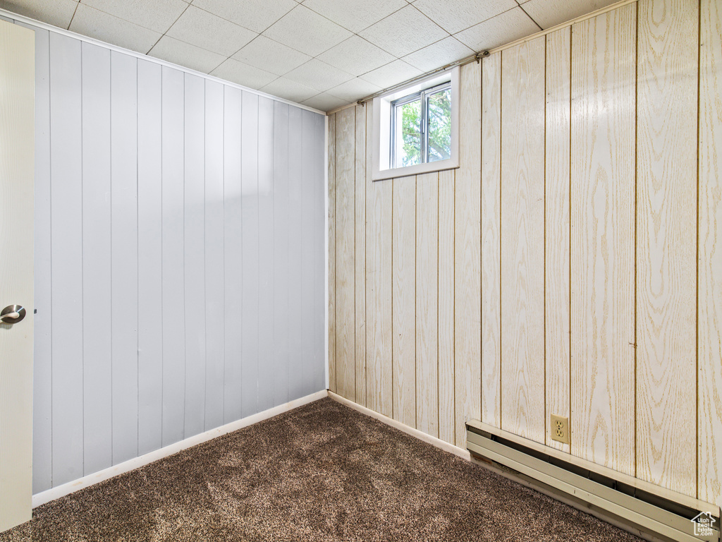 Basement featuring carpet flooring and a baseboard heating unit