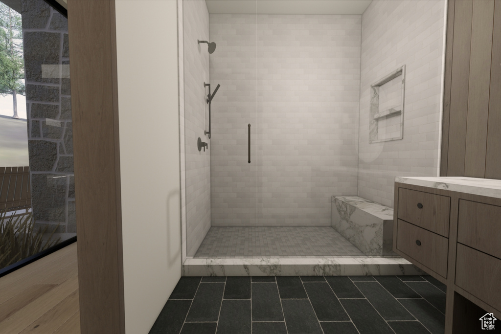 Bathroom featuring a shower with shower door, vanity, and tile patterned floors