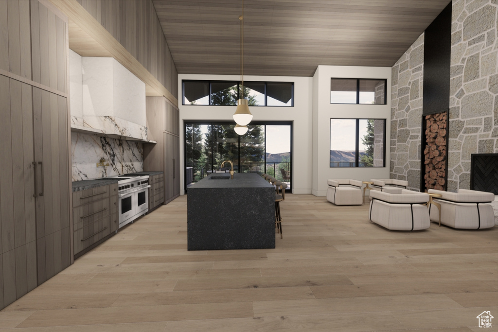 Kitchen with light wood-type flooring, wood ceiling, hanging light fixtures, a towering ceiling, and sink