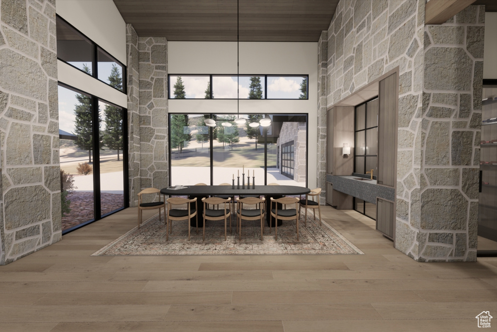 Unfurnished dining area featuring wood ceiling, wood-type flooring, and a high ceiling