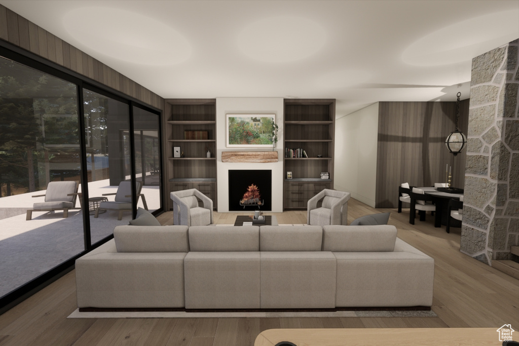 Living room with a stone fireplace, built in shelves, and wood-type flooring