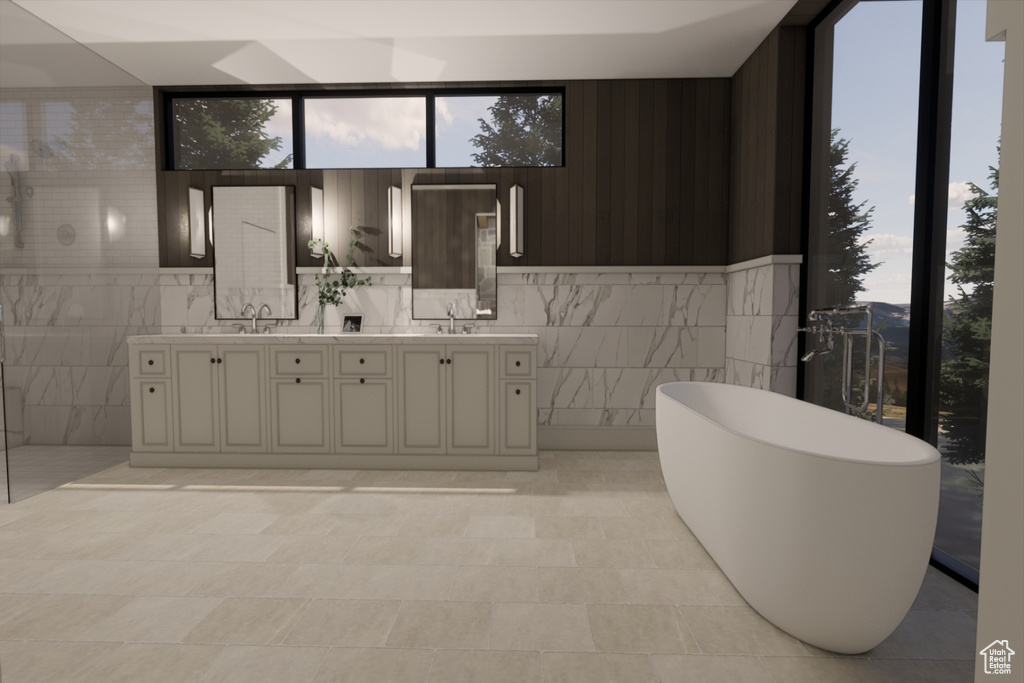 Bathroom with a tub, double sink vanity, tile patterned flooring, and tile walls