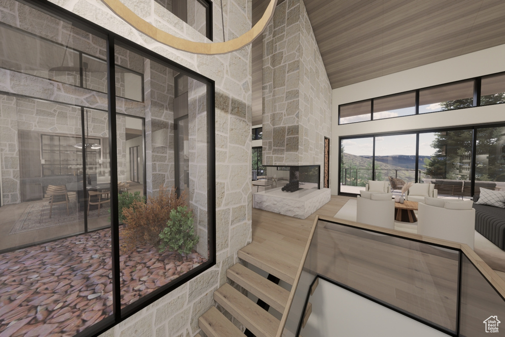 Bathroom featuring a stone fireplace, wooden ceiling, hardwood / wood-style floors, and a towering ceiling