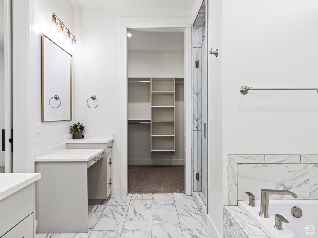 Bathroom with vanity, tile patterned flooring, and tiled bath