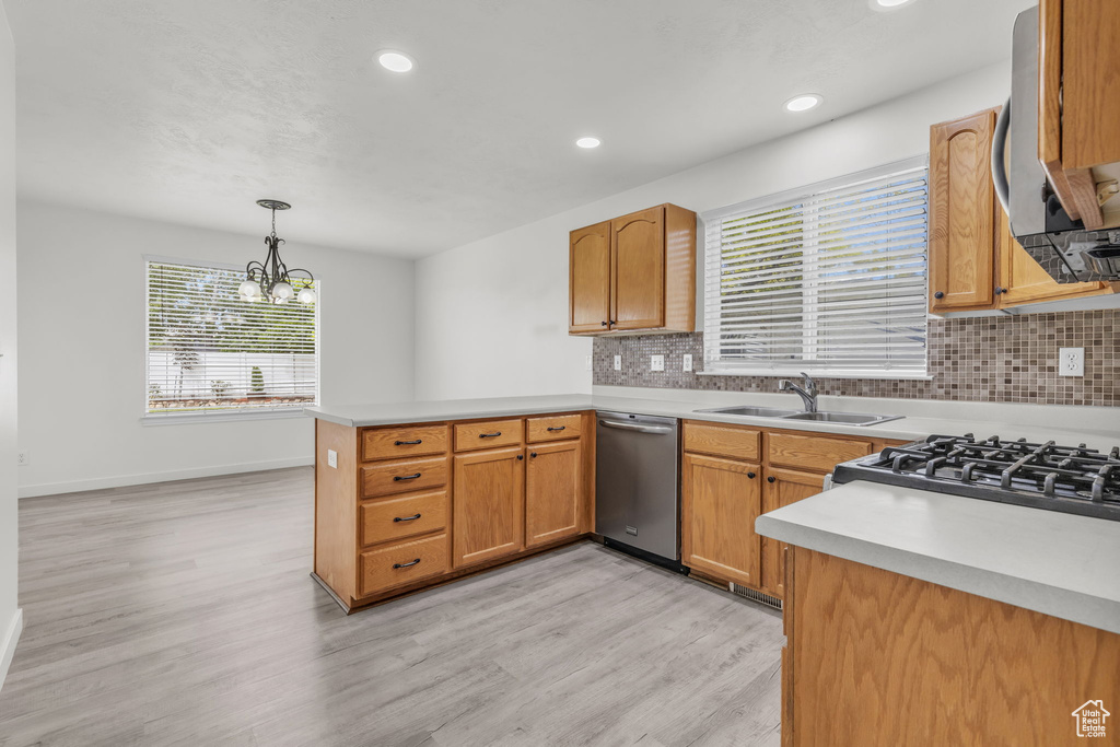 Kitchen featuring dishwasher, kitchen peninsula, and backsplash