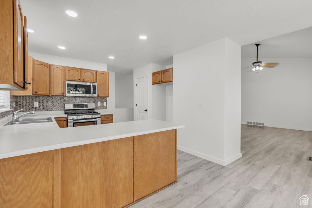 Kitchen featuring stainless steel appliances, light hardwood / wood-style flooring, sink, and kitchen peninsula