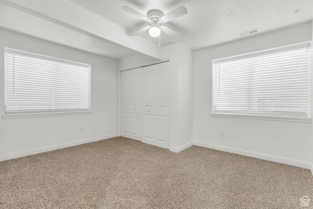 Unfurnished bedroom featuring carpet floors, ceiling fan, and a closet