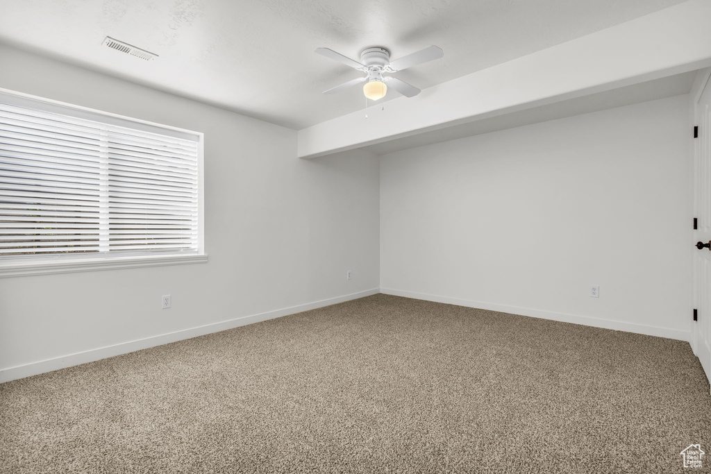 Carpeted empty room featuring ceiling fan