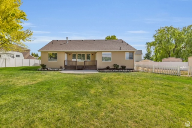 Back of property with a yard and a patio area