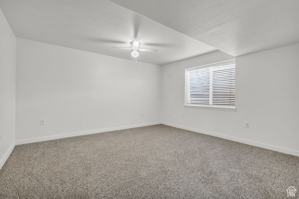 Empty room featuring carpet and ceiling fan